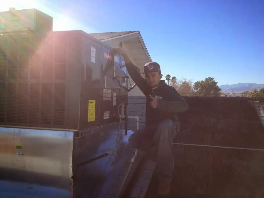 HVAC technician performing AC Tune-Up on a rooftop unit in Fairfield